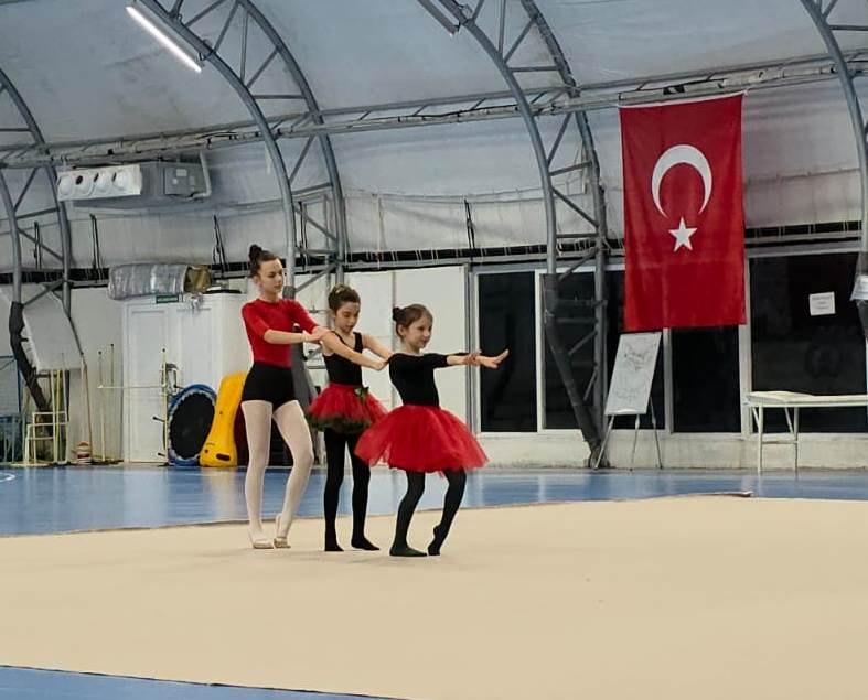 Yıl sonu gösterisinde sahne alan üç sporcu, minderde serbest seri sırasında