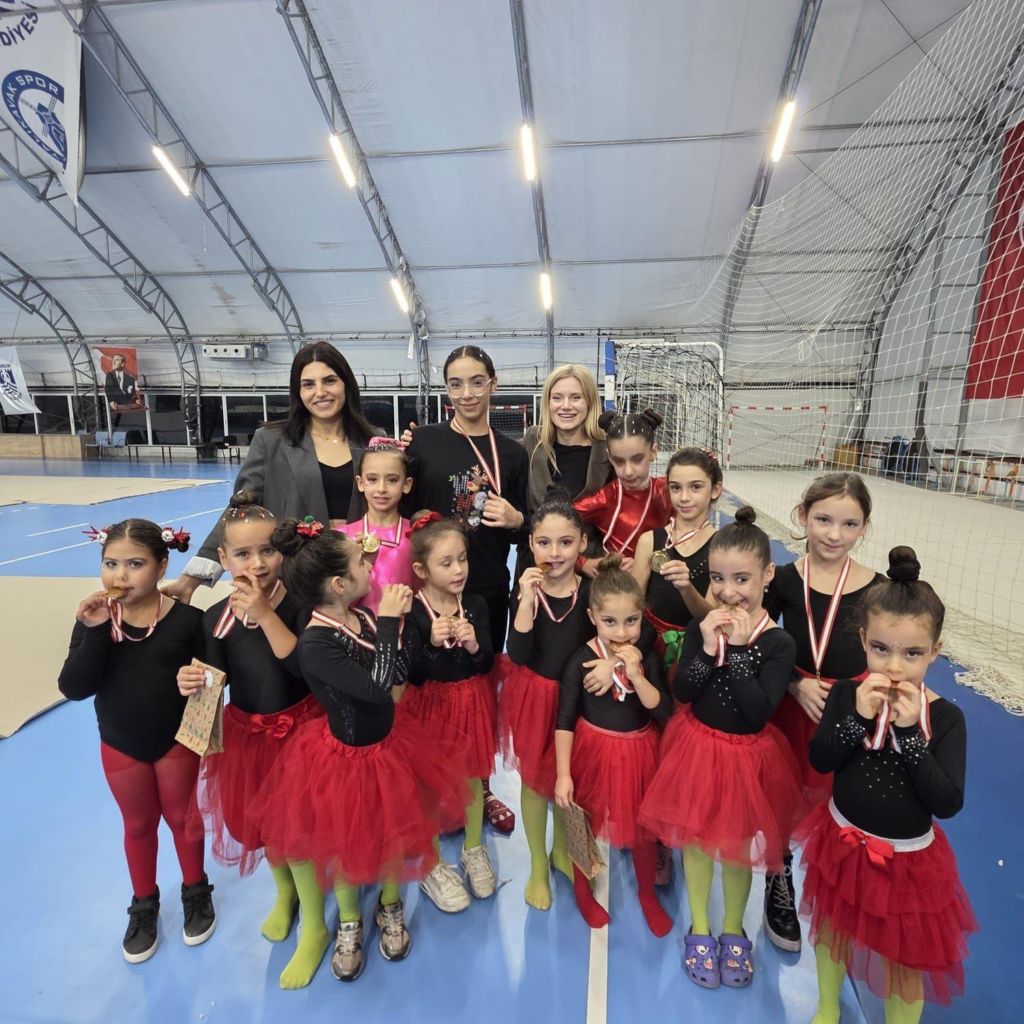The gymnastics group and their coaches after the year-end show, posing with their medals