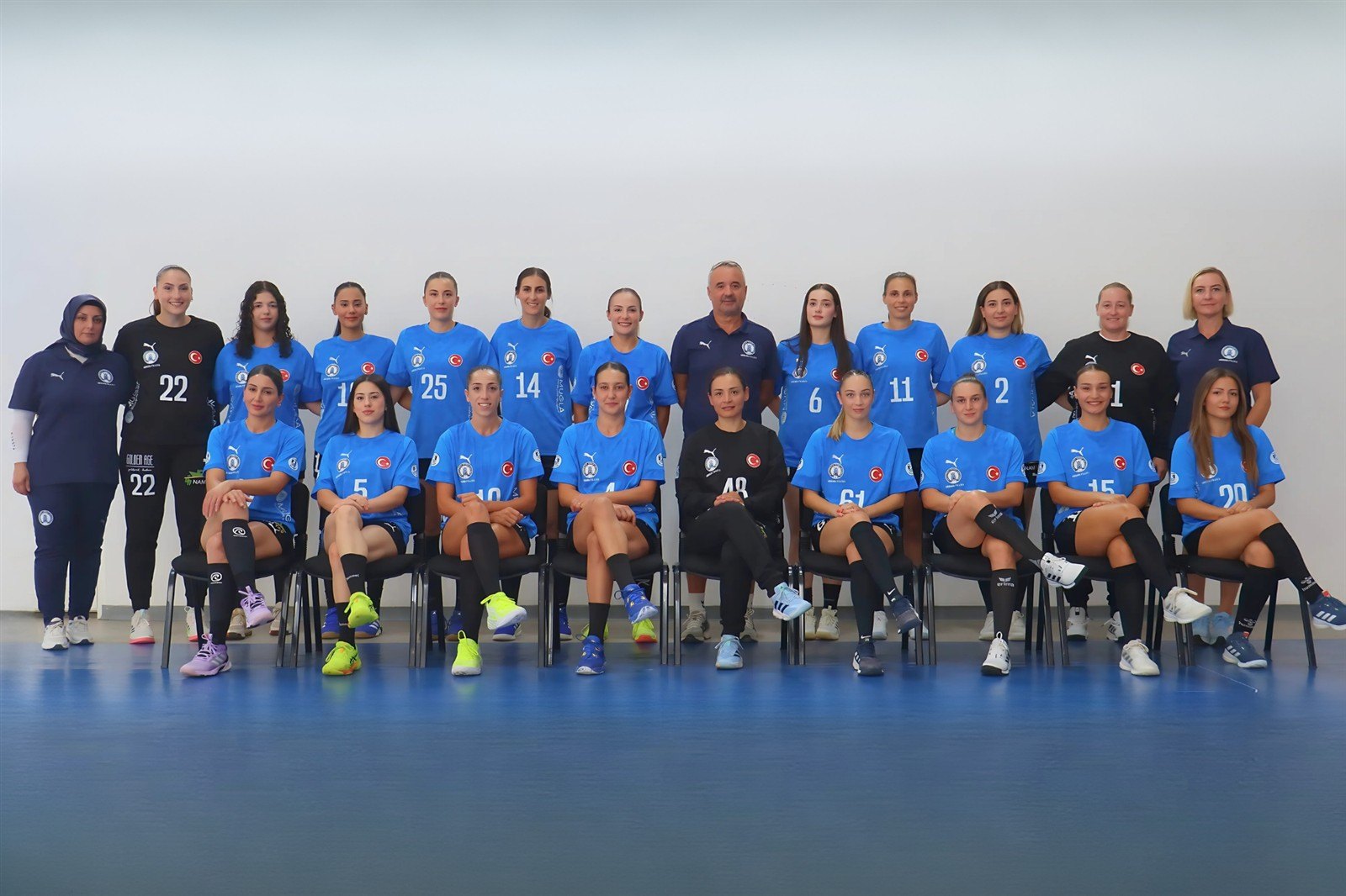 The squad and coaching staff in a group photo in their blue kits
